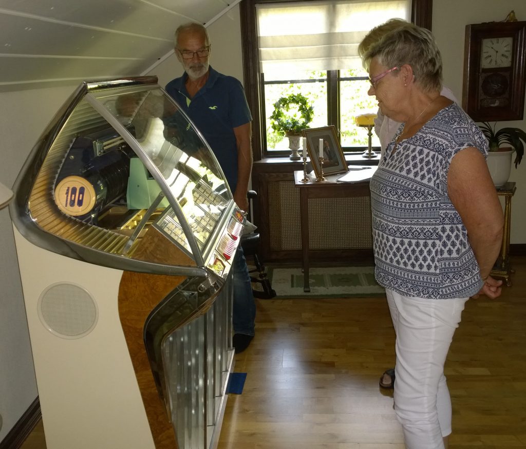 Lisbeth beundrar Jukeboxen tillsammans med Jan-Åke och Gun-Britt (skymd).